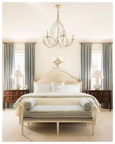 a bedroom with a bed, dressers and chandelier in it's center