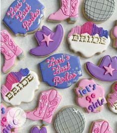 some decorated cookies are laying on a table with the words happy birthday written in pink, purple and blue