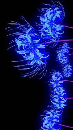 some blue flowers are lit up in the dark with red sticks sticking out of them