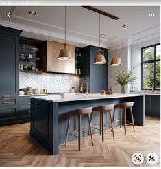 an image of a kitchen setting with blue cabinets and bar stools in the center