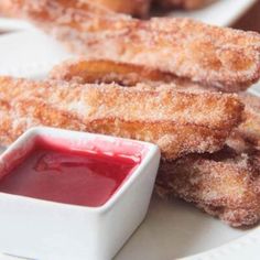 some fried food on a white plate with dipping sauce