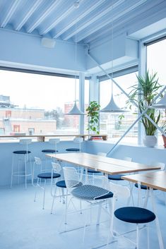 an empty room with blue chairs and tables