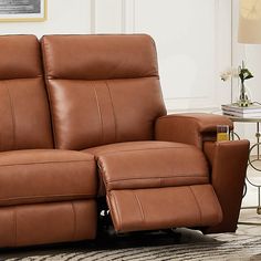 a brown leather reclining loveseat in a living room