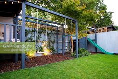 a backyard with a swing set and green grass