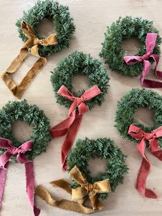 several wreaths with ribbons tied around them on a table