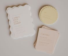 the wedding stationery is laid out on top of each other, including two cards