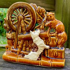 an animal figurine sitting on top of a wooden table next to a wheel