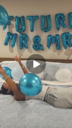 a woman laying on top of a bed next to blue and white balloons with the words future mr & mrs