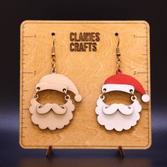 two wooden earrings with santa hats and beards on them