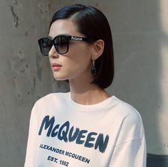 a woman wearing sunglasses and a t - shirt with the word moquen on it