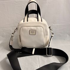 Nwt. It Can Be Carried With Top Handles Or Crossbody With Adjustable Strap. Logo In Front On Zip Pocket . Approximate Measurement: 7”H X 7”W X 4”D Strap Length: 54” Strap Drop: 25” Handle Length: 10” Handle Drop: 4” White Double Handle Shoulder Bag For On-the-go, Casual White Shoulder Bag For On-the-go, White Satchel Shoulder Bag With Mobile Phone Bag, White Shoulder Bag With Mobile Phone Pocket For Errands, White Crossbody Shoulder Bag With Mobile Phone Pocket, White Bags With Adjustable Strap And Double Handle, White Crossbody Travel Bag, White Shoulder Bag With Adjustable Double Handle, White Double Handle Shoulder Bag With Phone Pocket