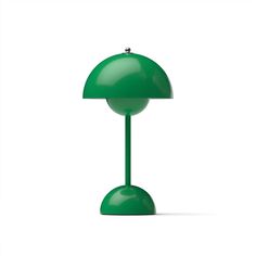 a green table lamp sitting on top of a white surface