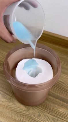 a person pouring blue liquid into a bowl