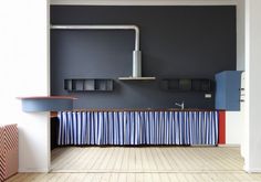 a kitchen with blue walls and red, white, and blue counter tops in the center