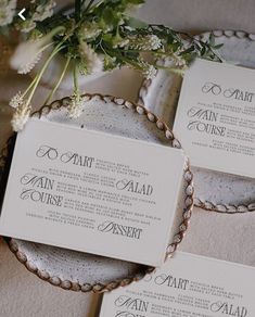 wedding stationery on plates with flowers and greenery