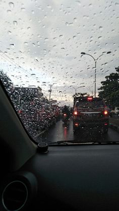 rain is falling on the windshield of a car