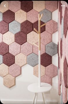 a white table and chair in front of a wall with hexagonal tiles on it