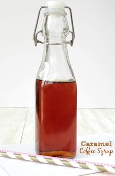 a glass bottle filled with liquid sitting on top of a white table next to a paper towel