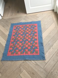 a blue and pink quilt on the floor