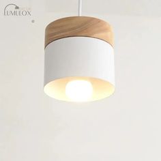 a white and wood light fixture hanging from a ceiling in a living room or bedroom