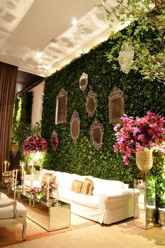 a living room filled with lots of furniture and flowers on top of a green wall