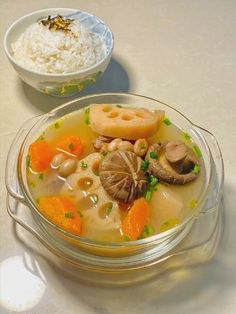 a bowl filled with soup and rice next to another bowl full of food on a table