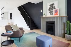 a living room with a couch, coffee table and stairs in the back ground area