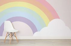 a white chair sitting in front of a rainbow wall mural