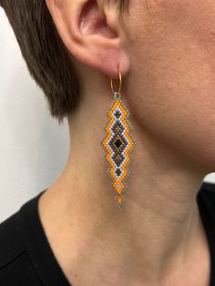 a close up of a person wearing some kind of beaded earring on their ear