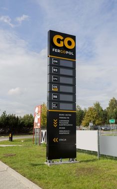 a large sign in front of a fenced off area with grass and signs on it