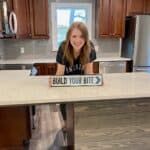 a woman standing behind a counter in a kitchen