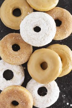 there are many donuts that are on the table together, including one with white and brown frosting