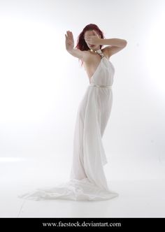 a woman in a white dress is posing for the camera with her hands behind her head