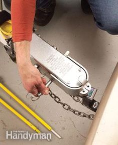 a person is holding onto a chain with two yellow handled tools in front of them