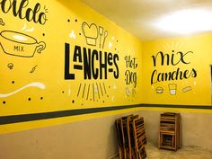 two yellow walls with black and white lettering painted on them, along with wooden folding chairs