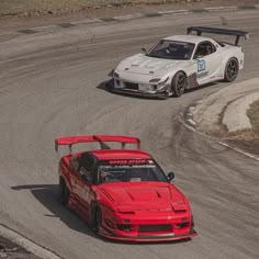 two cars driving on a race track next to each other