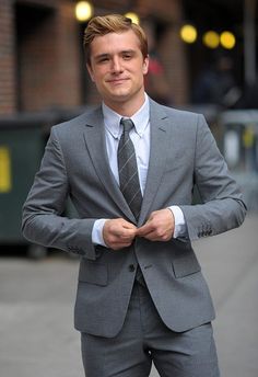 a man in a suit and tie standing on the street