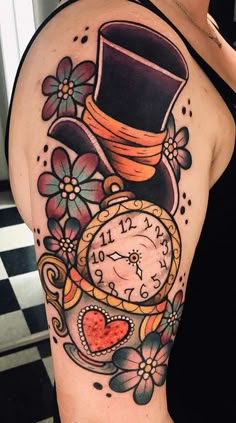 a woman's arm with a clock and flowers on it, which has a top hat