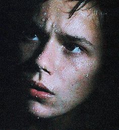 a close up of a person in the dark with drops of water on his face