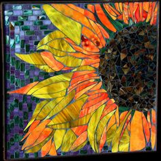 a stained glass sunflower is shown in the center of this mosaic tile wall art