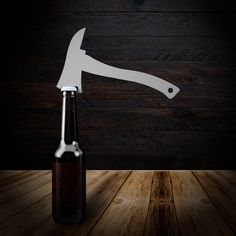 a bottle opener with a knife sticking out of it on top of a wooden table