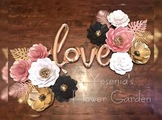 the word love spelled with flowers on a wooden surface