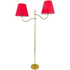 two red lamps sitting on top of a metal pole with one light on each side