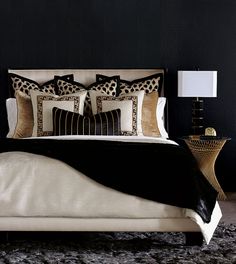 a black and white bedroom with leopard print on the pillows, headboard and foot board