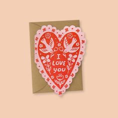 a red and white heart shaped card with the words i love you written on it