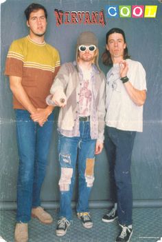 three young men standing next to each other in front of a sign that says nirvana