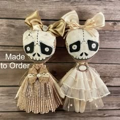 two little dolls made to look like they are wearing dresses and headbands with bows