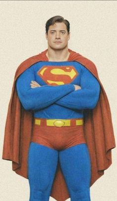 a man dressed as superman standing with his arms crossed