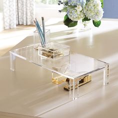 a clear desk with some pens and pencils in it on top of the table