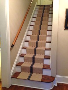 the stairs are made from cardboard and have black stripes on them, along with a wooden handrail